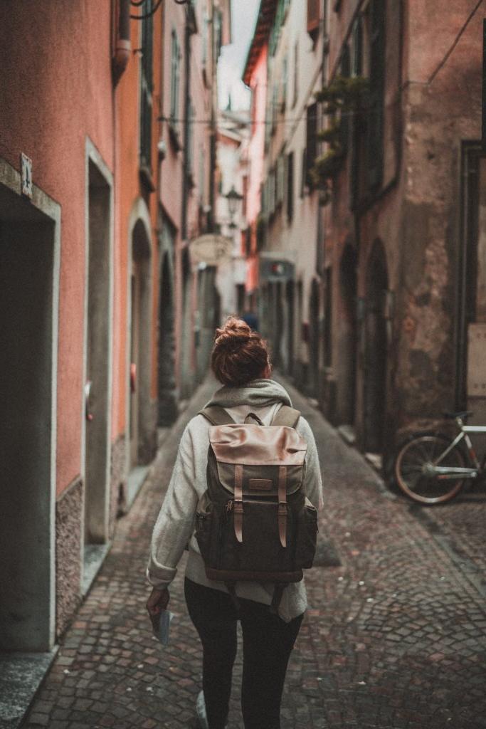 Woman with backpack walks down a european street